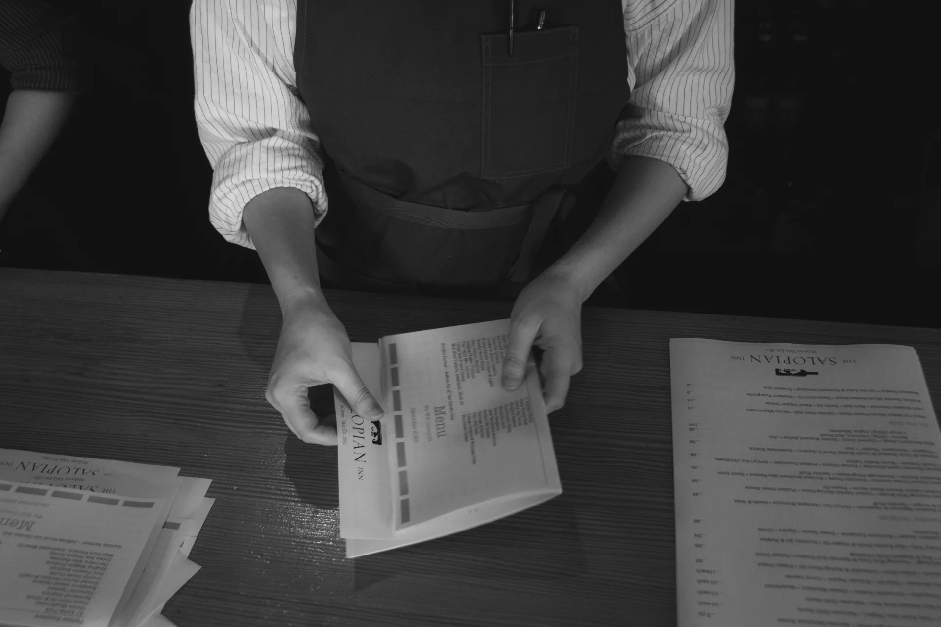 A front of house team member folding menus at The Salopian Inn