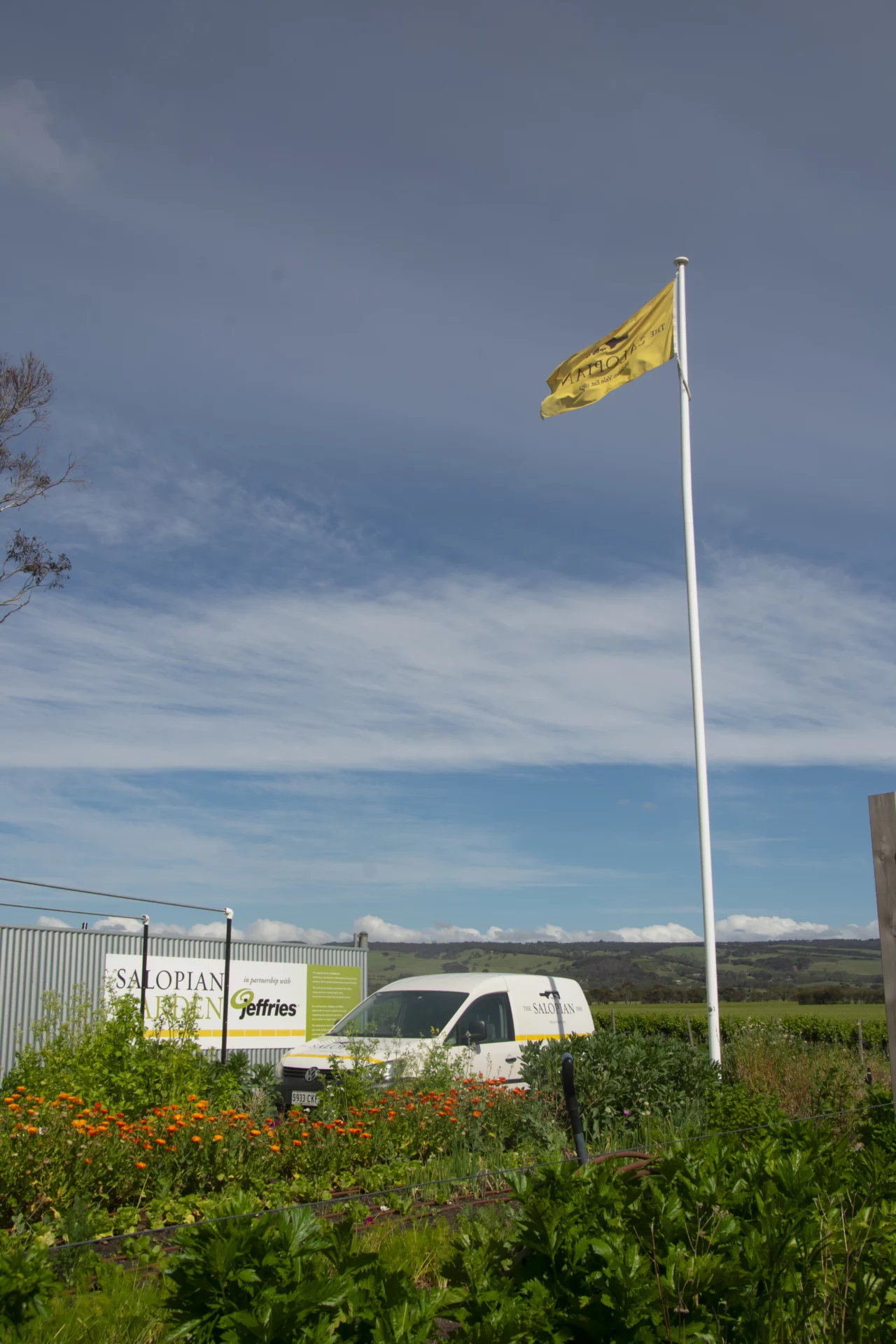 Salopian Inn kitchen garden in partnership with Jefferies, with the Salopian flag and McLaren Vale hills beyond
